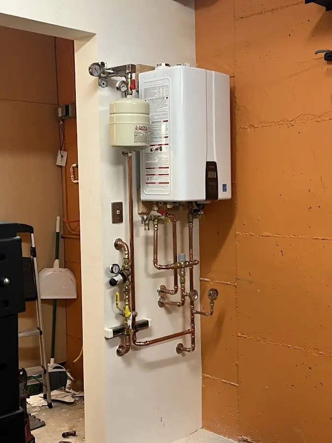 Plumbing technician inspecting water heater connections in Malvern